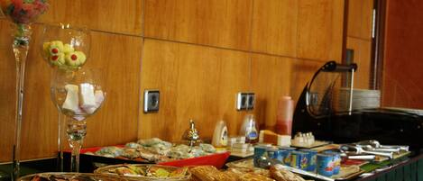 A buffet table with various food items and beverages.