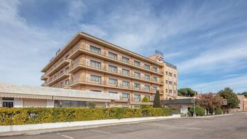 A multi-story hotel with a flat facade, balconies, and a clear sky.