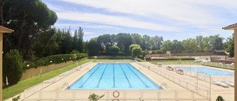 Piscina a l'aire lliure de temporada, para-sols i gandules