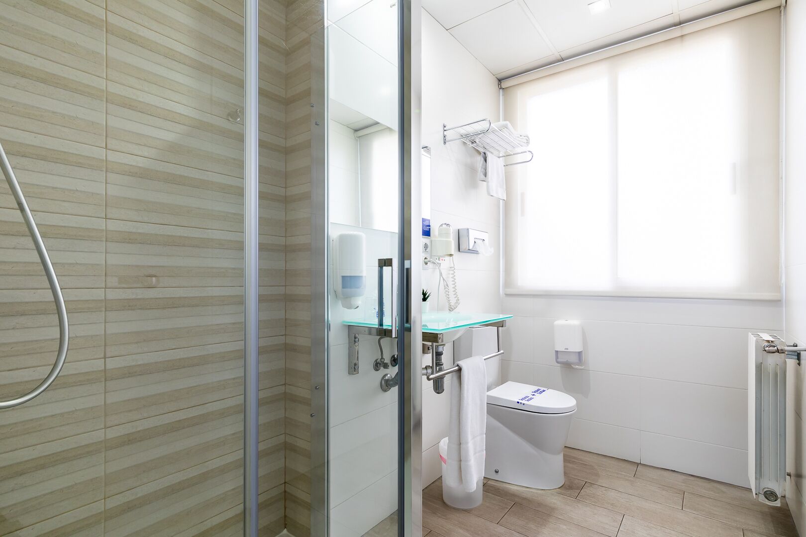 Une salle de bain moderne avec une douche à parois de verre, un lavabo en verre et des toilettes.
