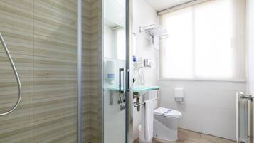 Une salle de bain moderne avec une douche à parois de verre, un lavabo en verre et des toilettes.
