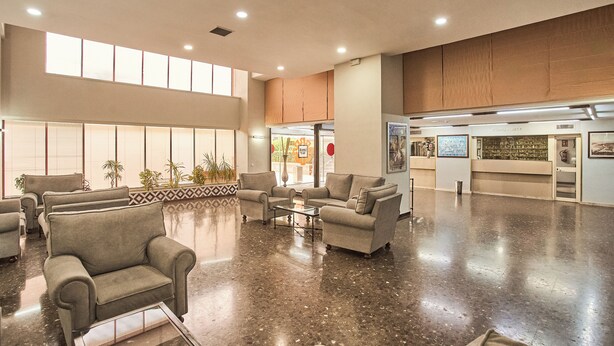 Un hall d’entrée spacieux, doté d’espaces de détente, d’une table basse et d’un comptoir de réception.