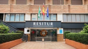Un bâtiment sur lequel on peut lire l’inscription « RESITUR » et qui est orné de plusieurs drapeaux.