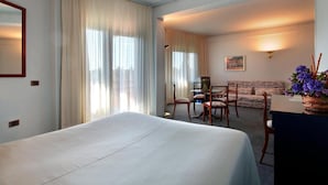Une chambre d’hôtel avec un lit, un bureau, une chaise et un canapé.
