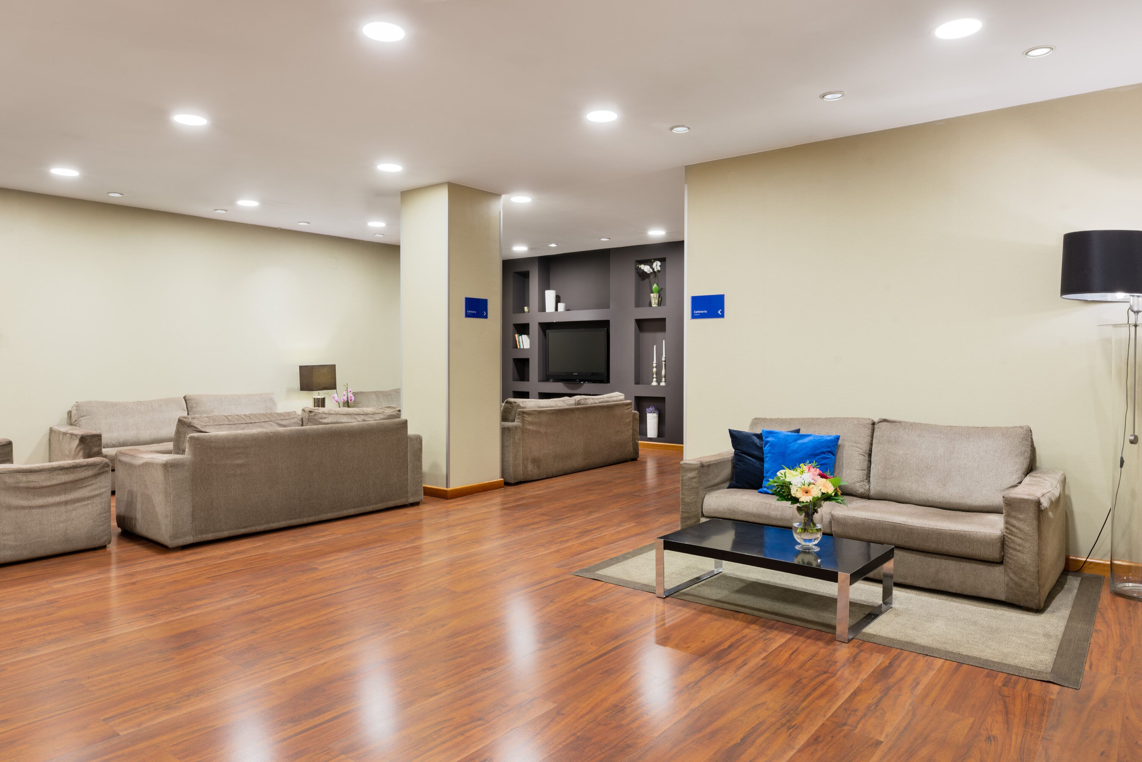 Una sala de estar moderna con un conjunto de sofás, una mesa de centro y un televisor de pantalla plana.