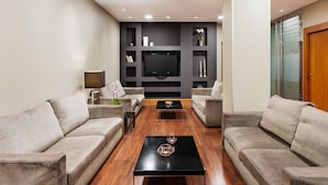 A modern living room with two sofas, a coffee table, and a flat-screen TV mounted on the wall. - Crisol Riosol (León)