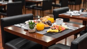 A breakfast setting with a table set for two, featuring croissants, fruit, and orange juice. - Crisol Riosol (León)