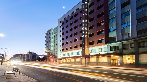 A multi-story hotel with a prominent sign reading "HOTEL RIOS". - Crisol Riosol (León)