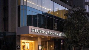Un hotel moderno con fachada de vidrio, llamado "Eurostars San Anton".
