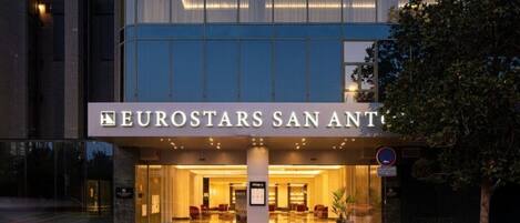 A hotel entrance with a modern design, featuring a large glass facade and a sign that reads 'EUROSTARS SAN ANTONIO'.