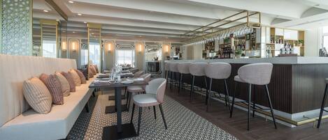 Ett modernt matområde med en bar, sittplatser och ett mönstrat golv.