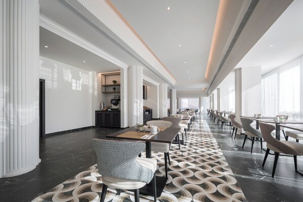 A modern hotel lobby with a long reception desk, seating area, and large windows. - Eurostars San Anton (Granada)