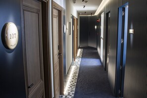 A hotel hallway with doors numbered 107 and 108, a check-in counter, and a 'Staff Only' sign. - Letoh Letoh Gran Vía (Madrid)
