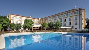 Un edificio grande con un patio central y piscina.