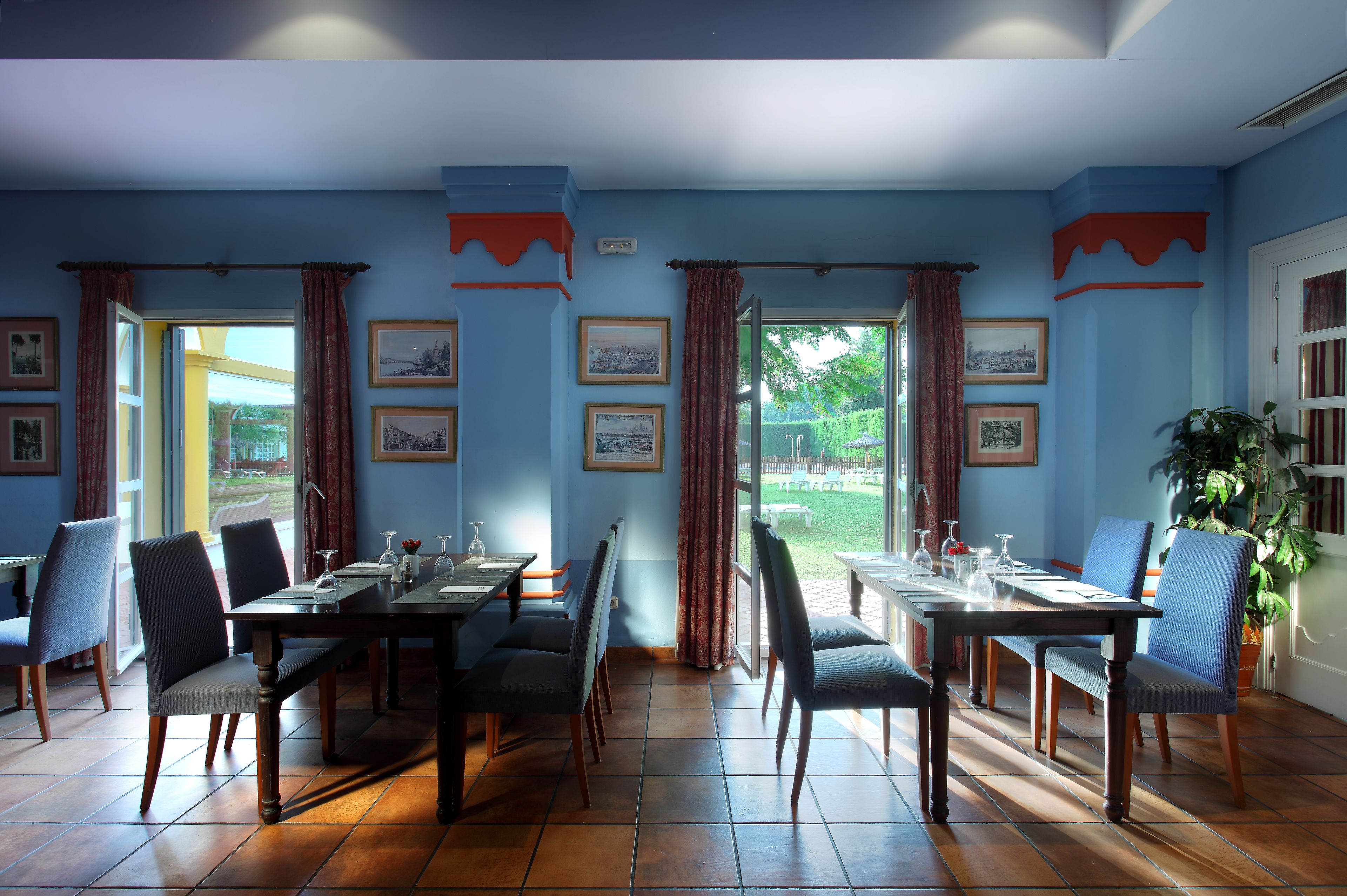 Un comedor con una mesa preparada para cuatro, sillas y vistas al exterior.