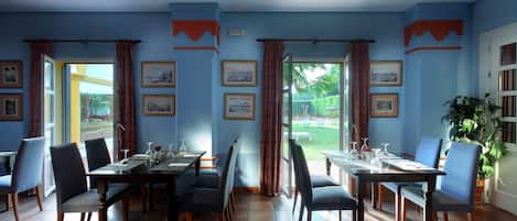 Un comedor con una mesa preparada para cuatro, sillas y vistas al exterior.