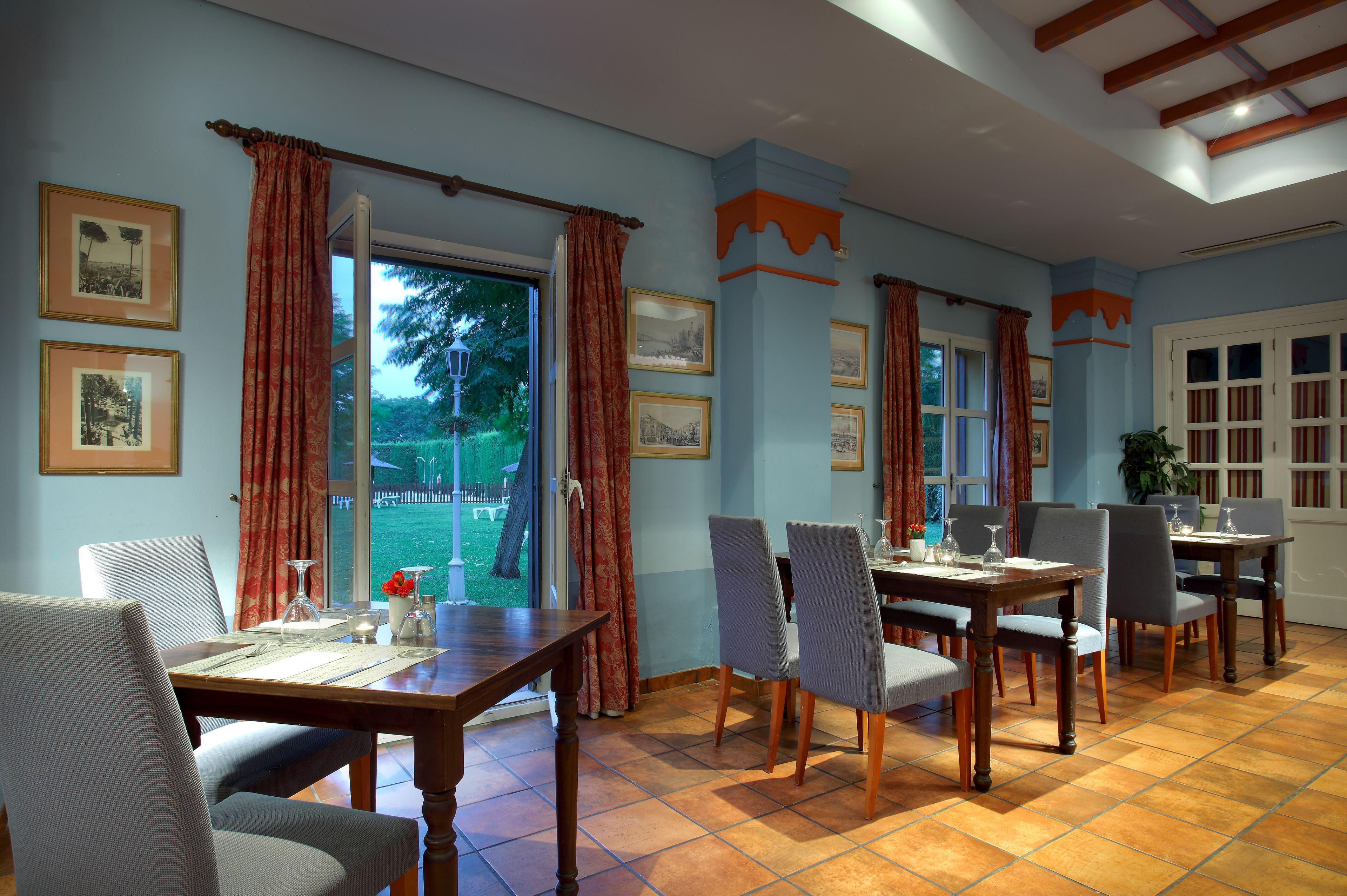 A dining area with a table set for four, chairs, and a view of the outdoors.