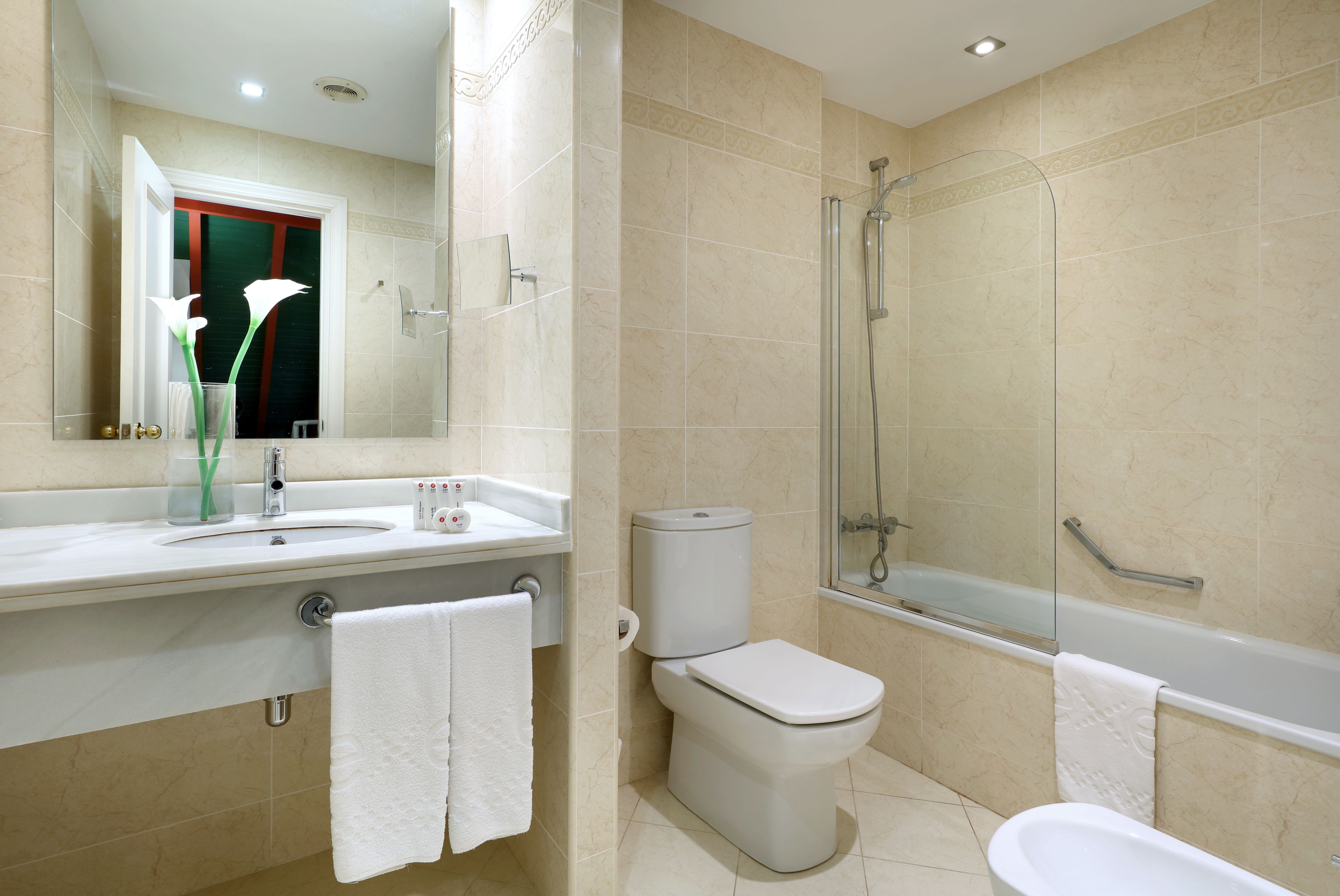 Un baño moderno con lavamanos, inodoro y bañera.