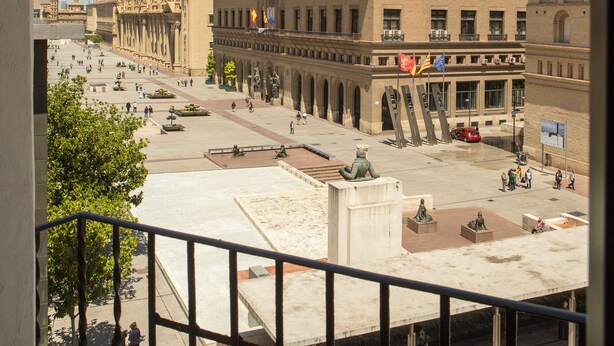 A spacious plaza with a prominent building featuring multiple towers and a statue in the foreground. - Tibur Hotel (Zaragoza)