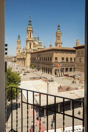 A spacious plaza with a prominent building featuring multiple towers and a statue in the foreground. - Tibur Hotel (Zaragoza)