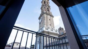 Vista de una torre histórica a través de la barandilla de un balcón.