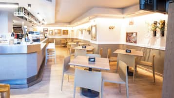 A modern restaurant with a bar area, multiple seating options, and a clean, well-lit interior.