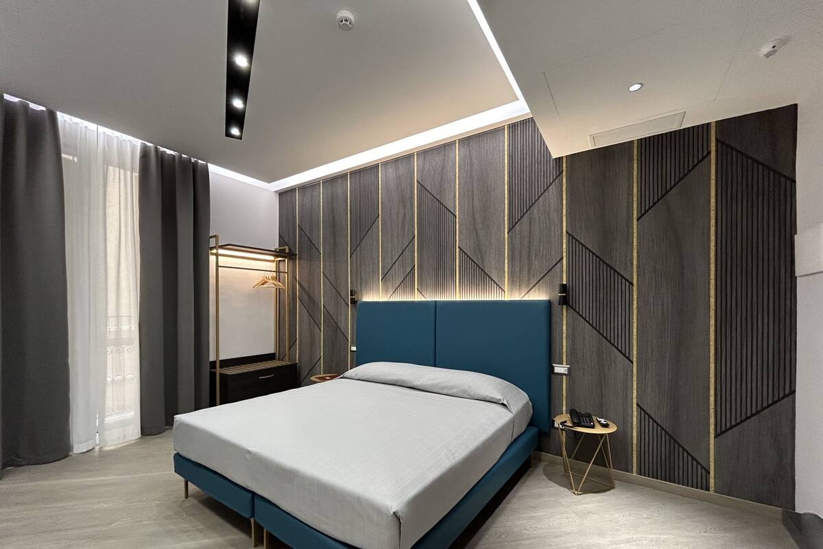 Ein modernes Schlafzimmer mit Bett, Nachttisch und Kleiderschrank.