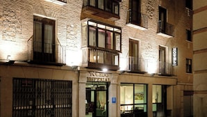 A hotel facade with a stone exterior, multiple balconies, and a sign indicating it is a hotel. - Sercotel Toledo Imperial (Toledo)