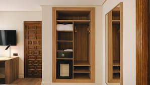 A room with a built-in wooden wardrobe, a television on a stand, and a small desk with a lamp. - Sercotel Toledo Imperial (Toledo)