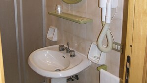 Un baño con lavamanos, espejo y ducha.