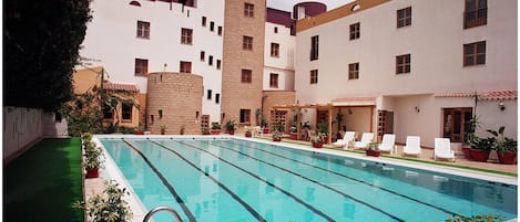 Una piscina al aire libre, sombrillas