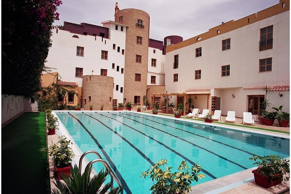 Una piscina al aire libre, sombrillas