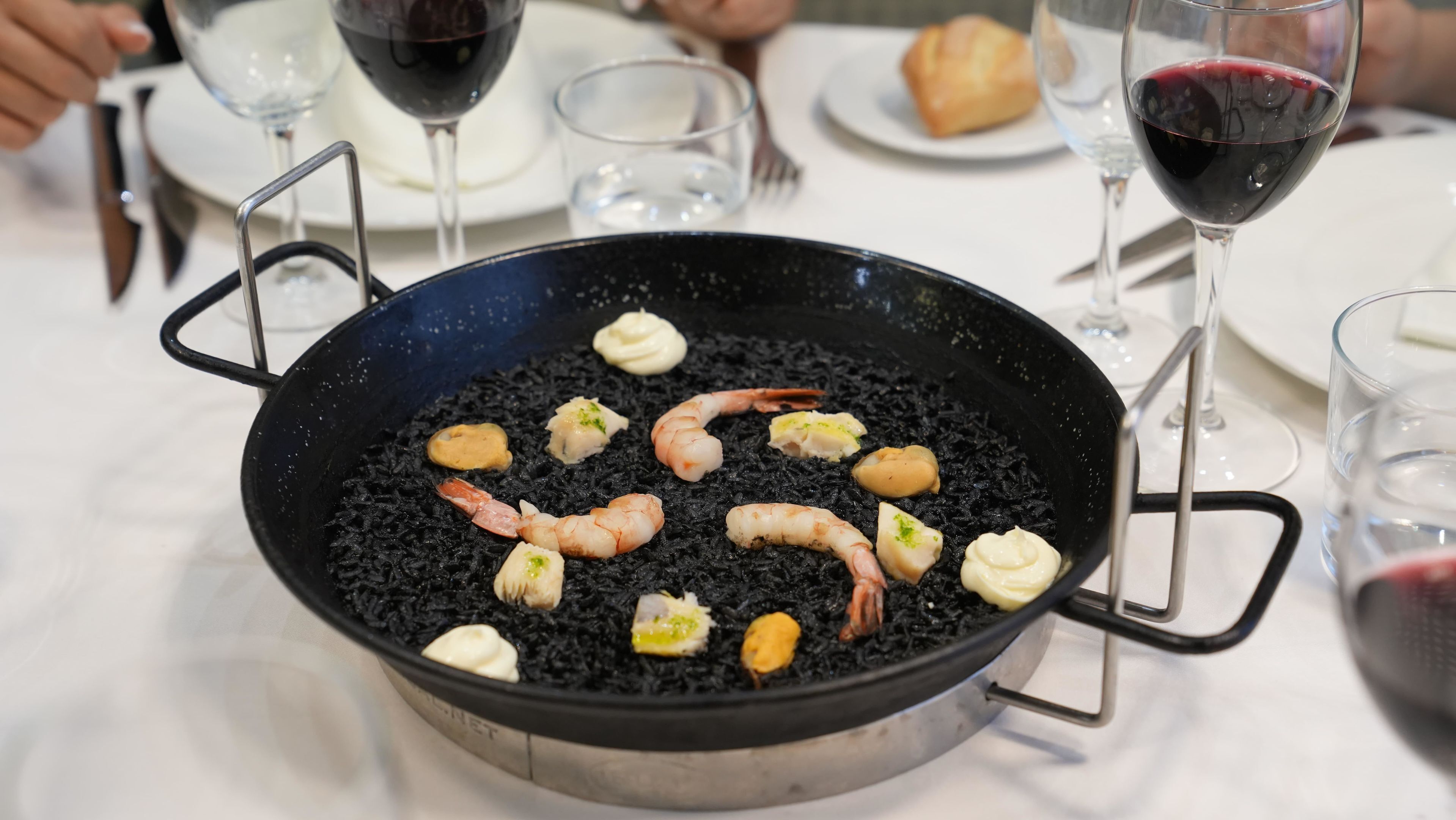 Ein Fischgericht mit Garnelen und weiteren Zutaten in einer Pfanne.