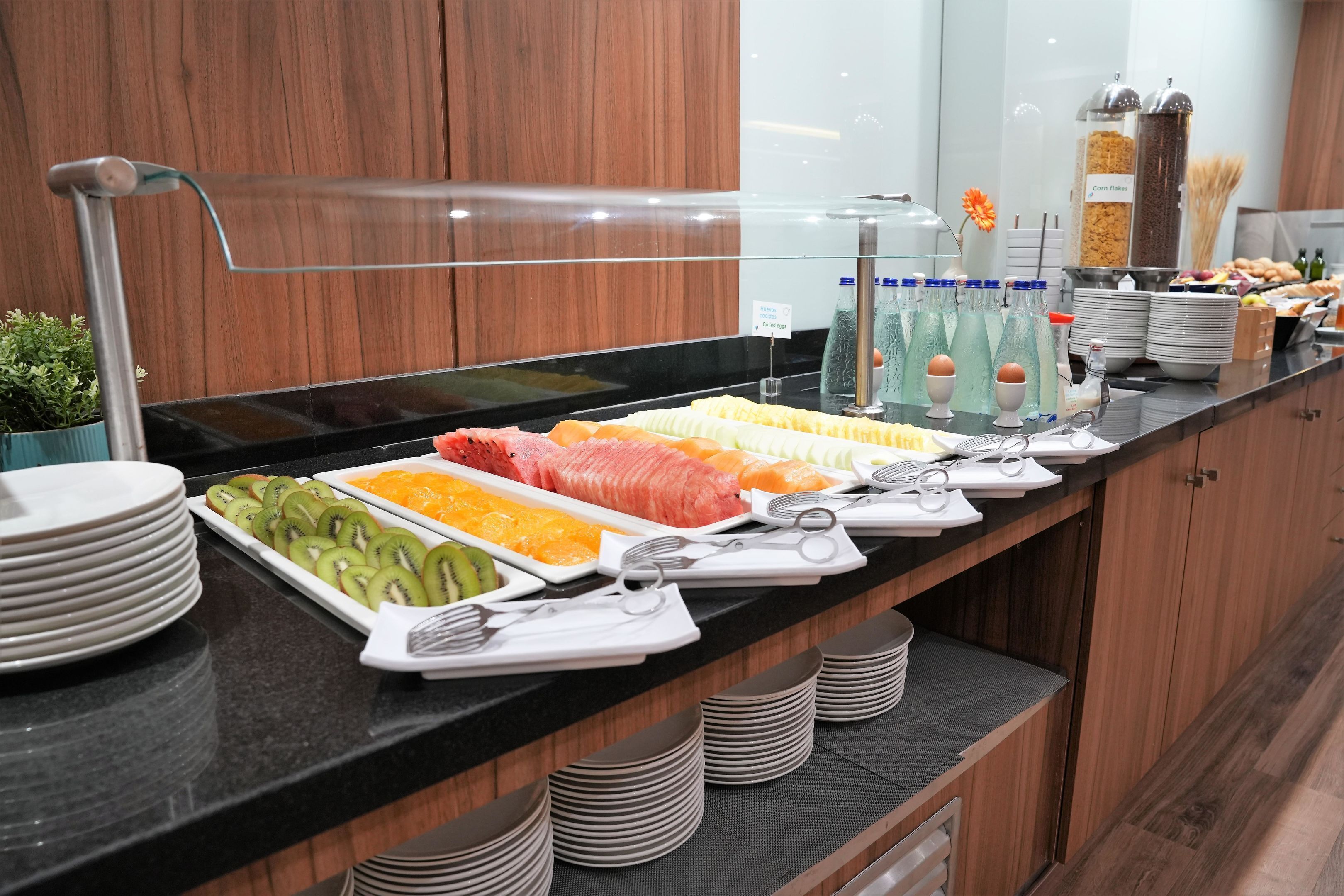 A buffet with various fruits, vegetables, and meats.