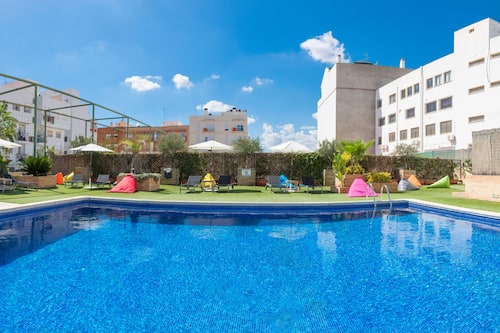 Una piscina al aire libre, sombrillas, tumbonas