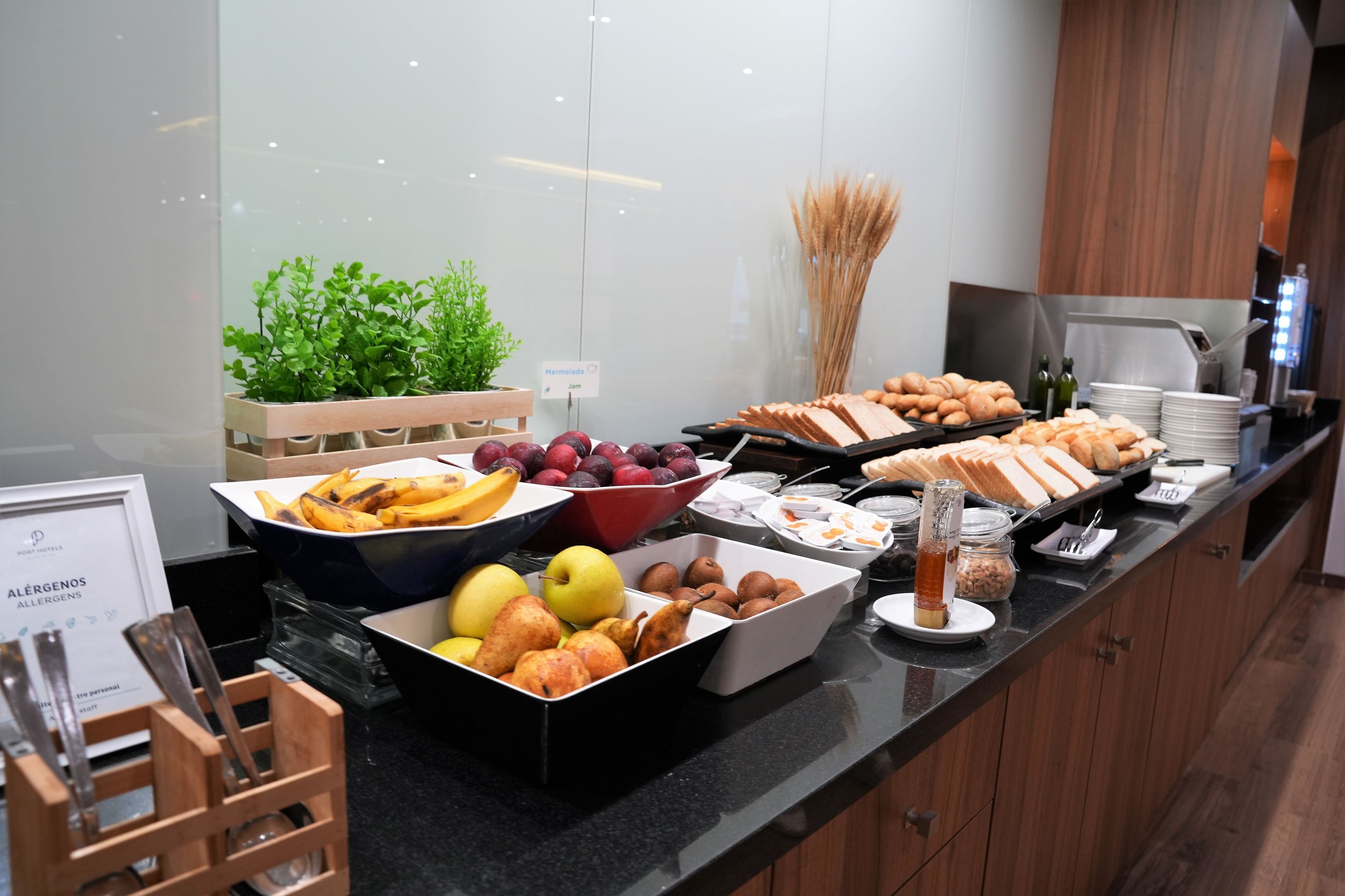 A buffet with various fruits, pastries, and beverages.