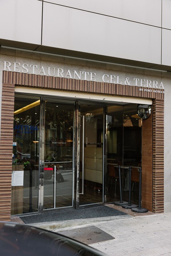 A restaurant entrance with glass doors, a wooden facade, and a sign reading "RESTAURANTE CEL & TERRA BY PORT HOTELS". - Hotel Port Feria Valencia (Valencia)