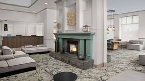 A spacious living room with a fireplace, seating area, and a kitchen in the background.