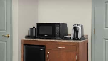 Una kitchenette equipada con microondas, cafetera y refrigerador.