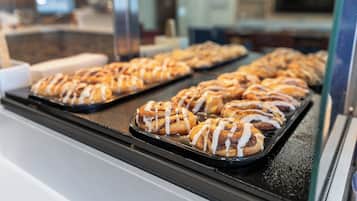 A display case with trays of cinnamon rolls.