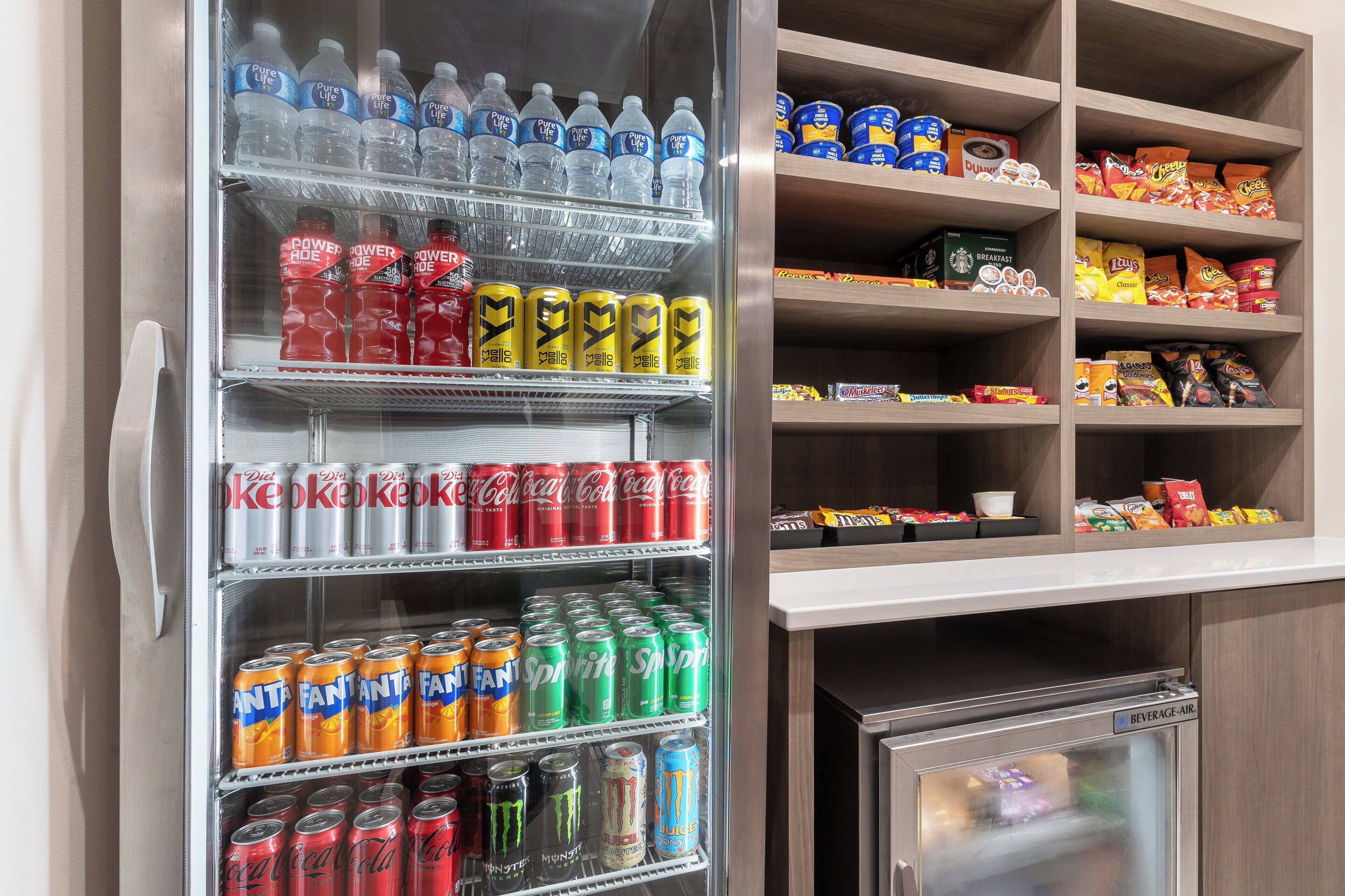 Un refrigerador de bebidas repleto de diversas opciones, incluyendo refrescos dietéticos, energizantes y agua embotellada.