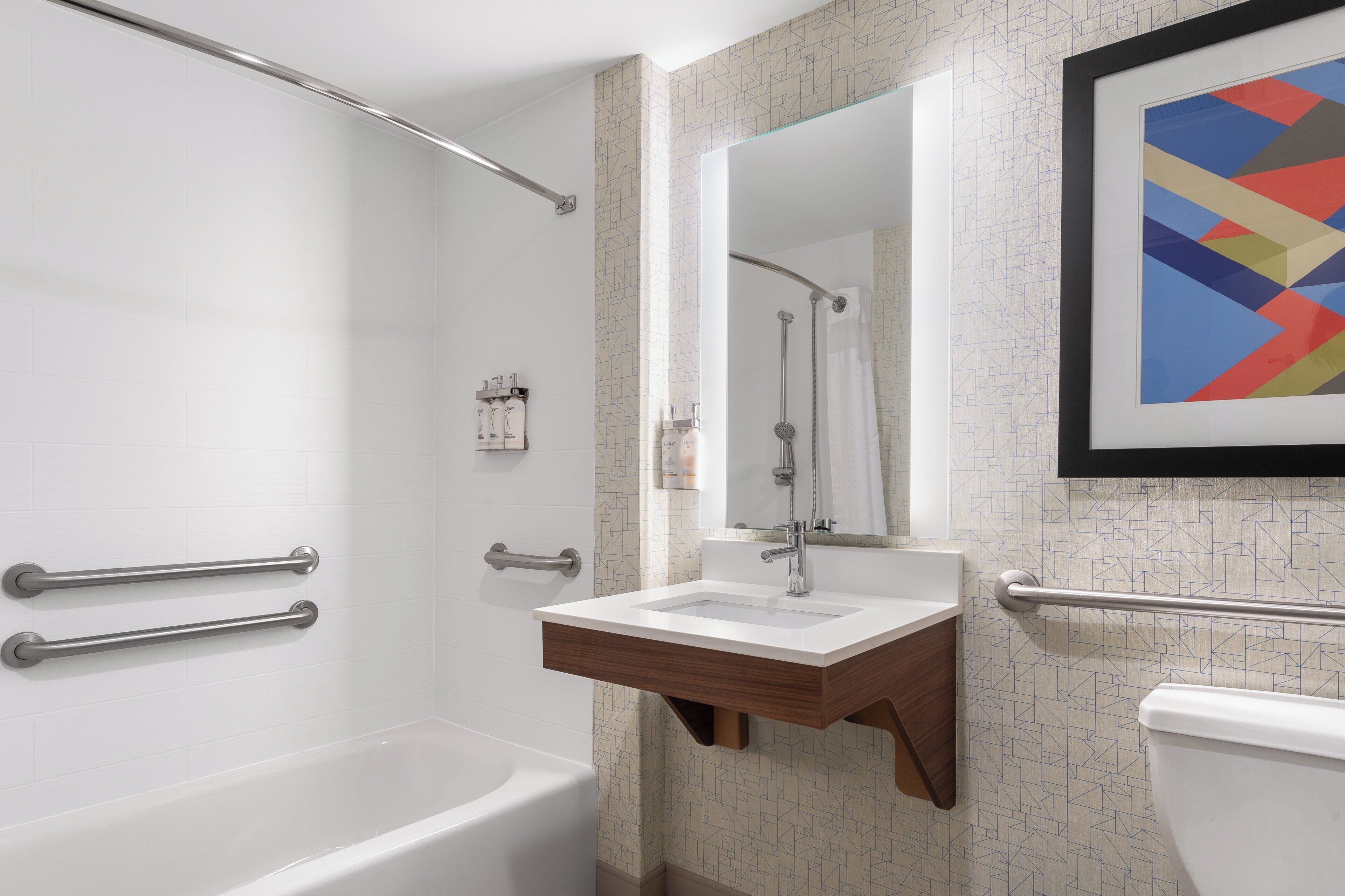 Een moderne badkamer met een bad, een wastafel en een toilet.