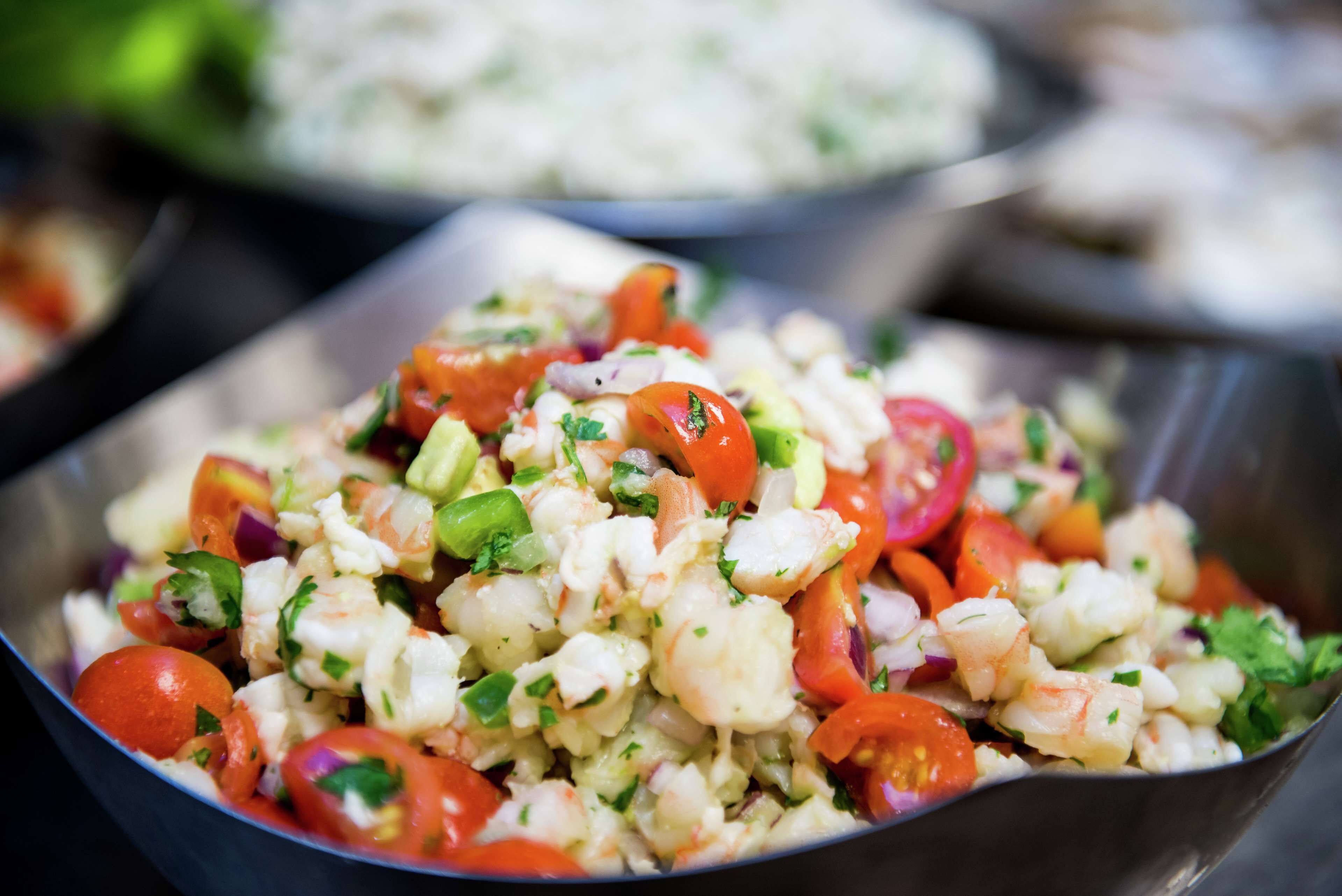Uma salada de marisco com camarão, tomate e ervas.
