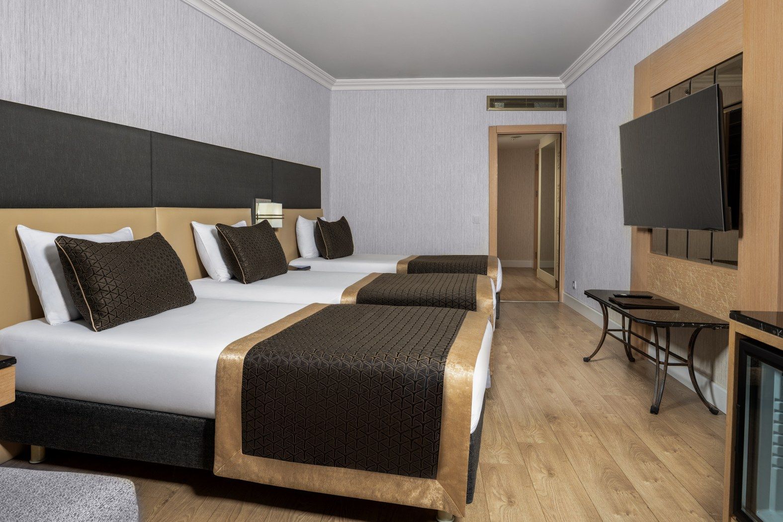 Une chambre d’hôtel avec deux lits, une télévision et une petite table.