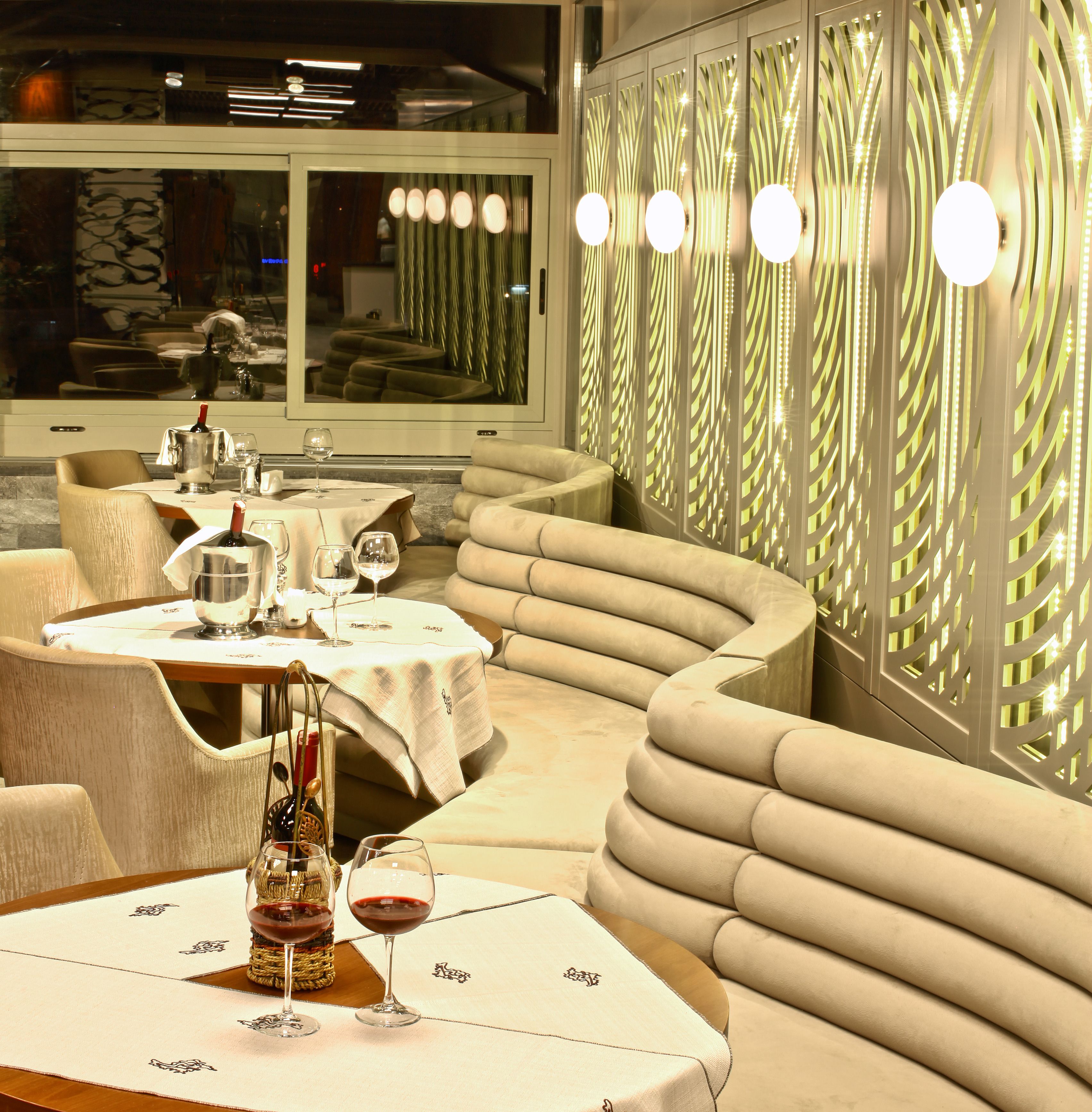 Un restaurant avec des tables rondes, des sièges confortables et un éclairage décoratif.
