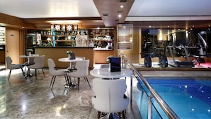 A hotel lobby with a bar area, seating, and a swimming pool. - Darkhill Hotel (Istanbul)
