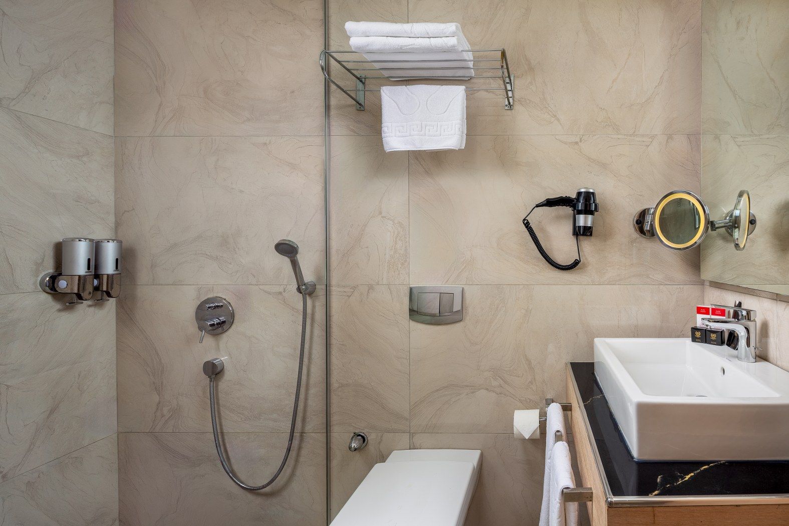 A modern bathroom with a shower, toilet, and sink.