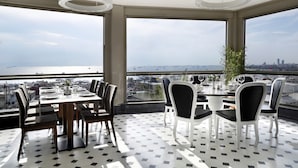 A dining area with a view of the city skyline, large windows, and modern furniture. - Darkhill Hotel (Istanbul)