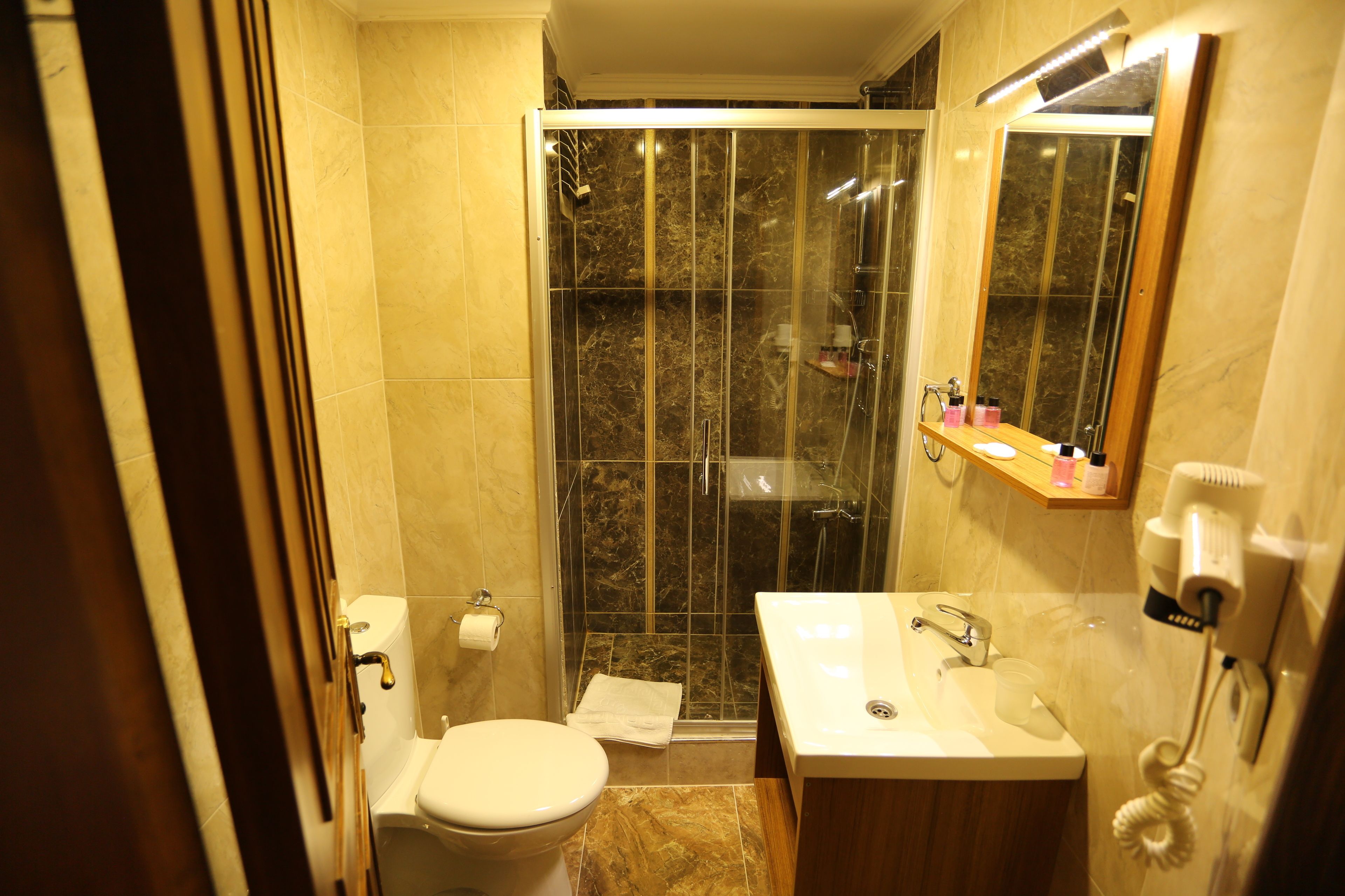 A bathroom with a toilet, sink, and shower.
