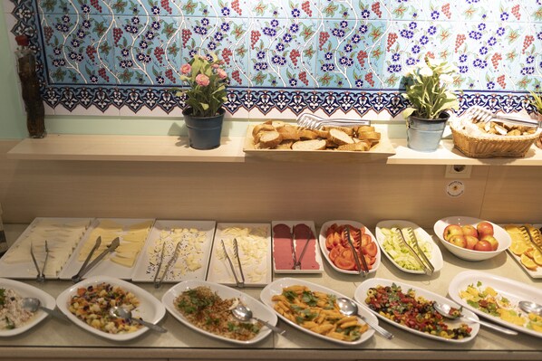 Een buffet met diverse gerechten en een betegelde achterwand.
